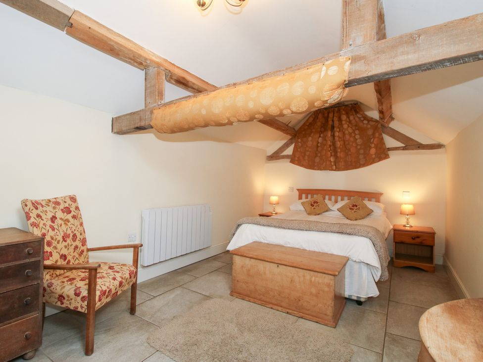 A bedroom with a bed and bedside tables at Millstone Cottages - Millstone Cottage in Westbury