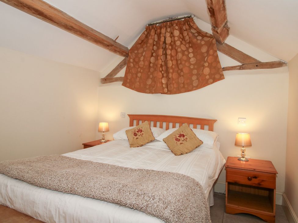 A bedroom with a bed and bedside tables at Millstone Cottages - Millstone Cottage in Westbury