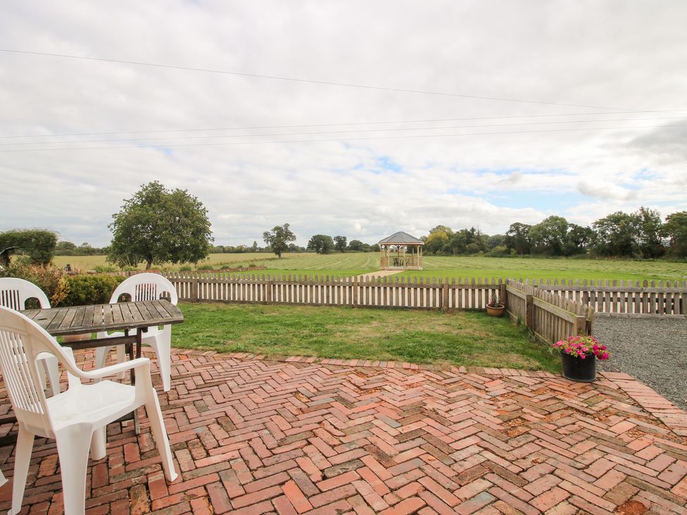 An outdoor area with a table and chairs at Millstone Cottages - Millstone Cottage in Westbury