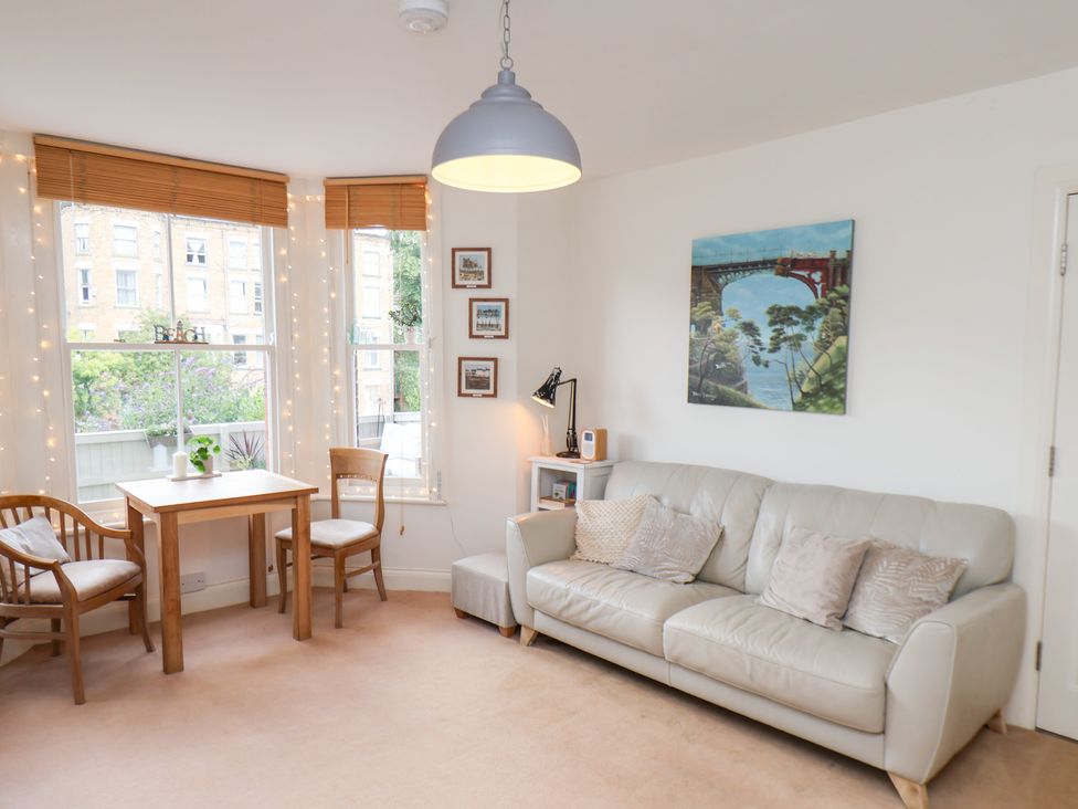 A living room with a sofa and dining table at Happy Days in Scarborough