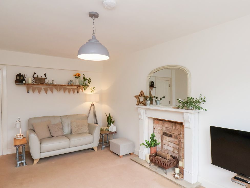 A living room with a sofa and a fireplace at Happy Days in Scarborough