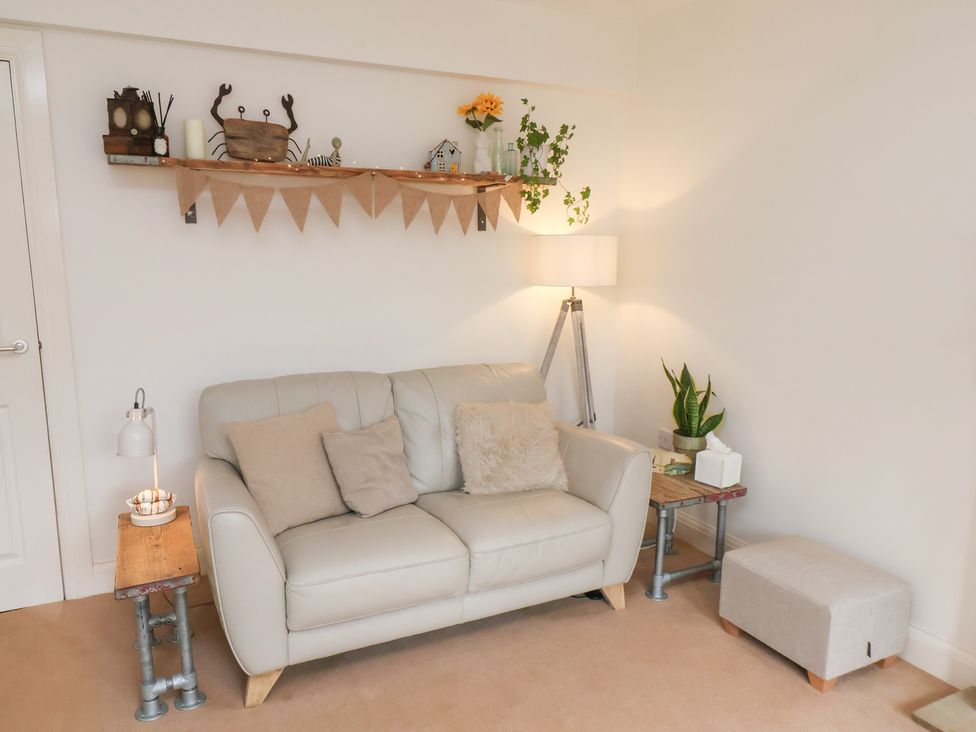 A living room with a sofa and decorative items at Happy Days in Scarborough