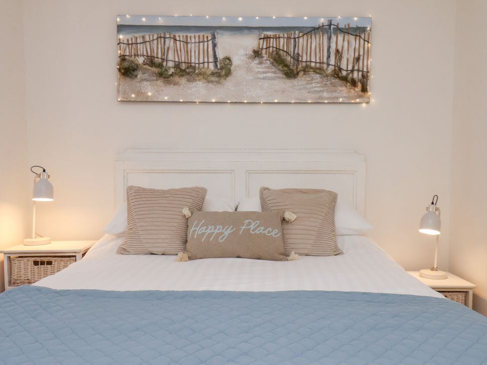 A bedroom with a bed and bedside lamps at Happy Days in Scarborough