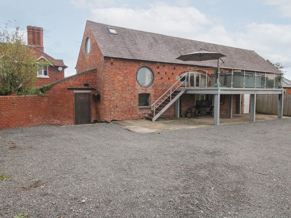 A brick building with a balcony and stairs at Millstone Cottages - Breidden View
