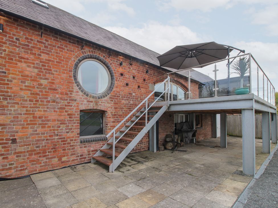 An outdoor patio area with stairs and an umbrella at Millstone Cottages - Breidden View Westbury