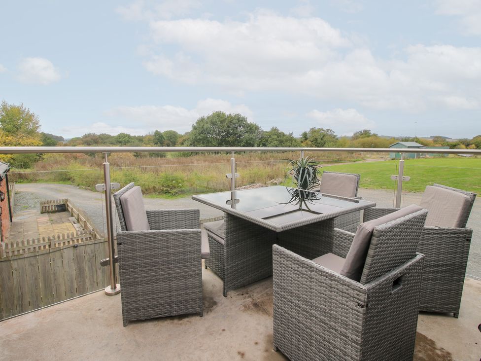 An outdoor terrace with a table and chairs at Millstone Cottages - Breidden View Westbury