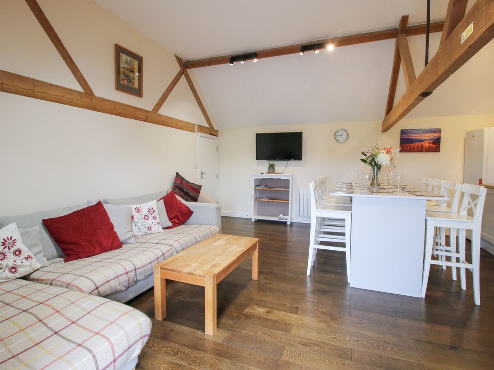 A living room with a sofa and dining area at Millstone Cottages - Breidden View in Westbury