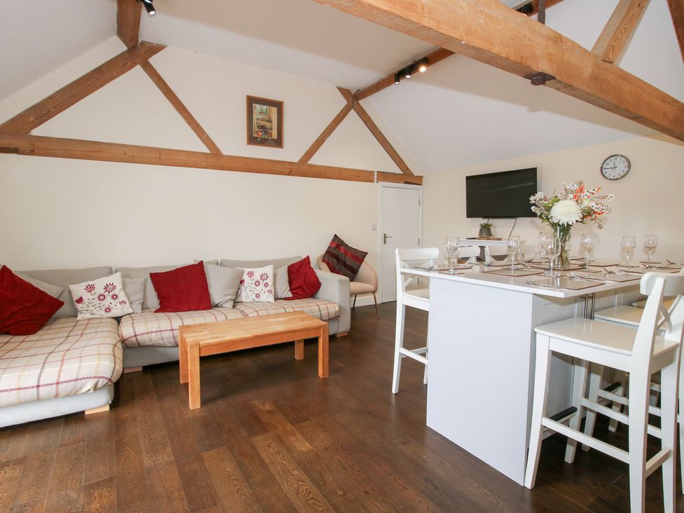 A living room with a sofa and dining area at Millstone Cottages - Breidden View Westbury