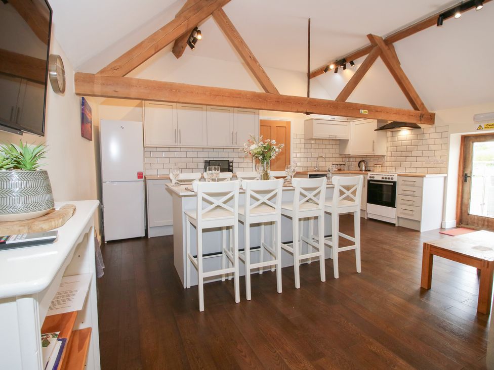 A kitchen with appliances and seating at Millstone Cottages - Breidden View in Westbury