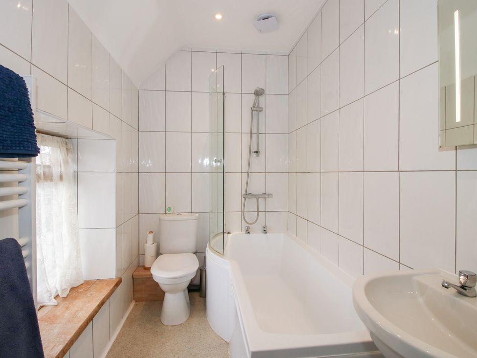 A bathroom with a bathtub, shower, toilet and sink at Millstone Cottages - Breidden View, Westbury
