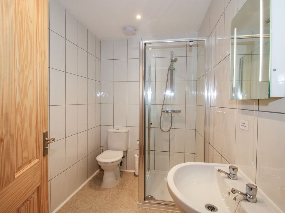 A bathroom with a shower, toilet, and sink at Millstone Cottages - Breidden View in Westbury