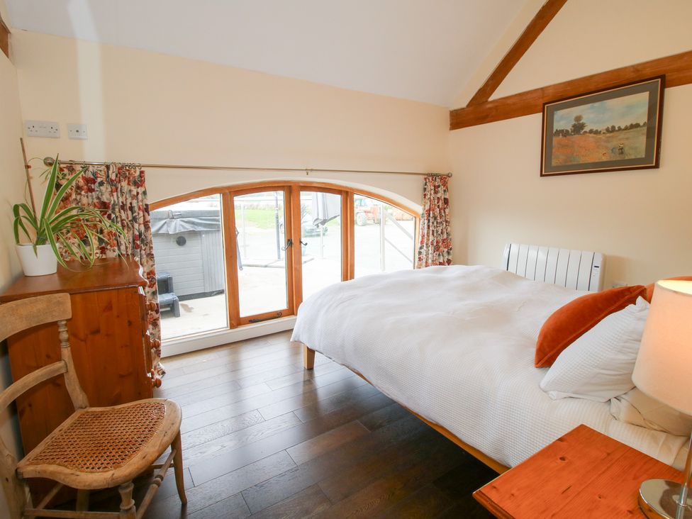A bedroom with a bed and window at Millstone Cottages - Breidden View Westbury