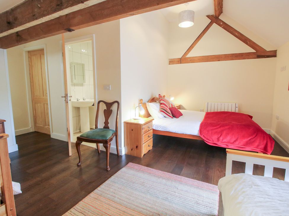 A bedroom with a bed and chair at Millstone Cottages - Breidden View Westbury