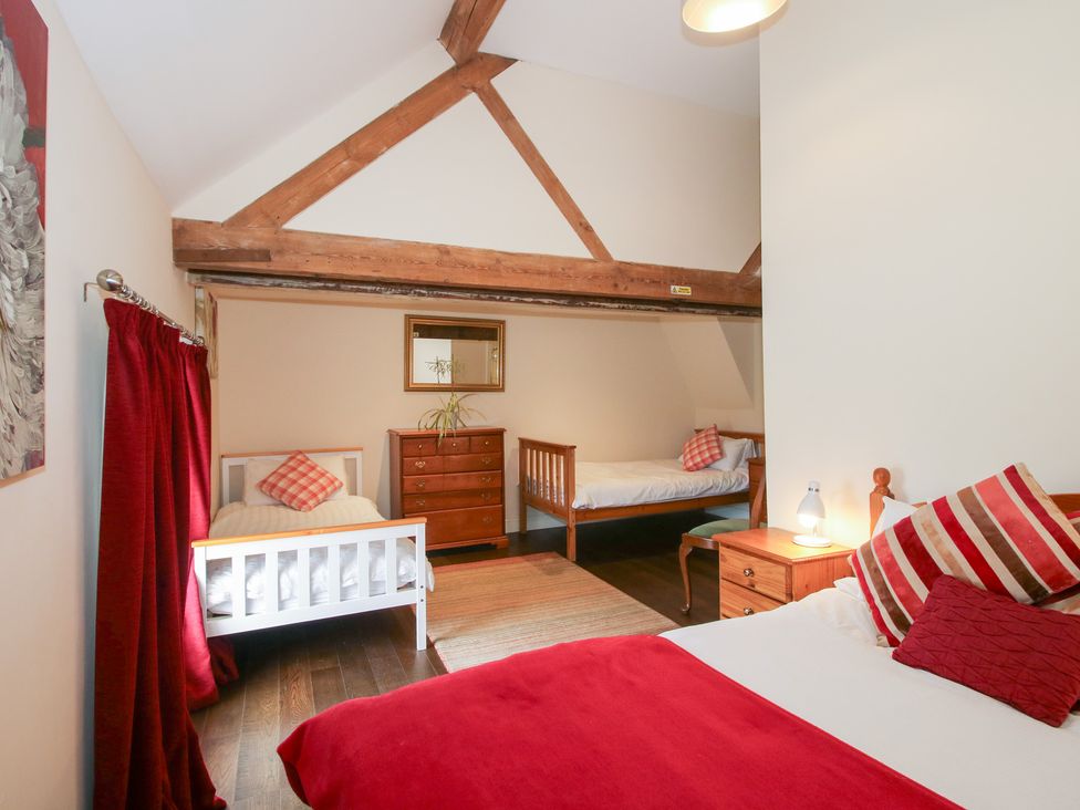A bedroom with beds and furniture at Millstone Cottages - Breidden View in Westbury