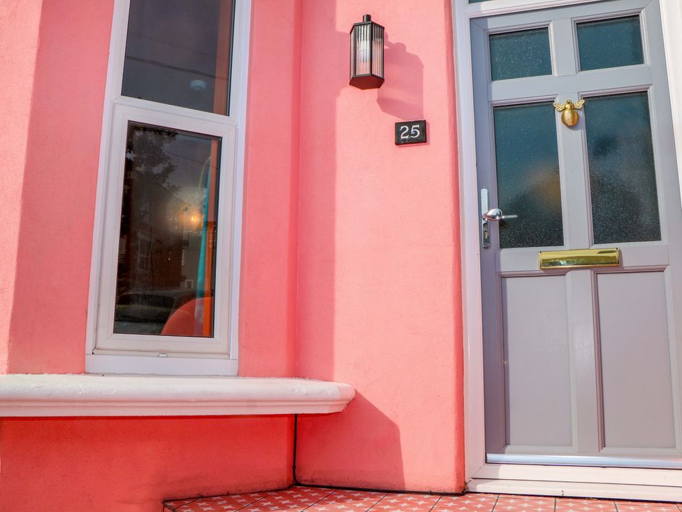 A front entrance with a pink wall and door at Hasting Heights in Hastings
