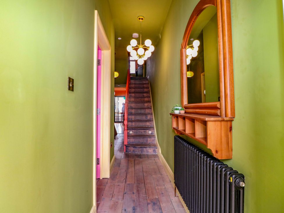 A hallway with a mirror and stairs at Hasting Heights in Hastings