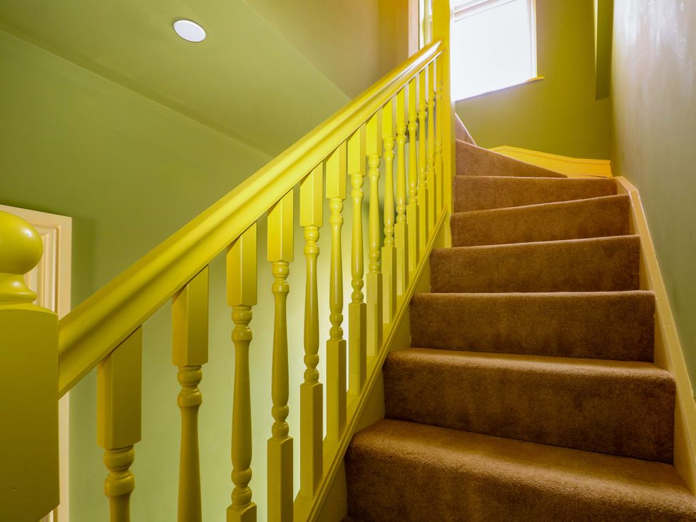 A staircase with yellow balustrade and carpet at Hasting Heights in Hastings