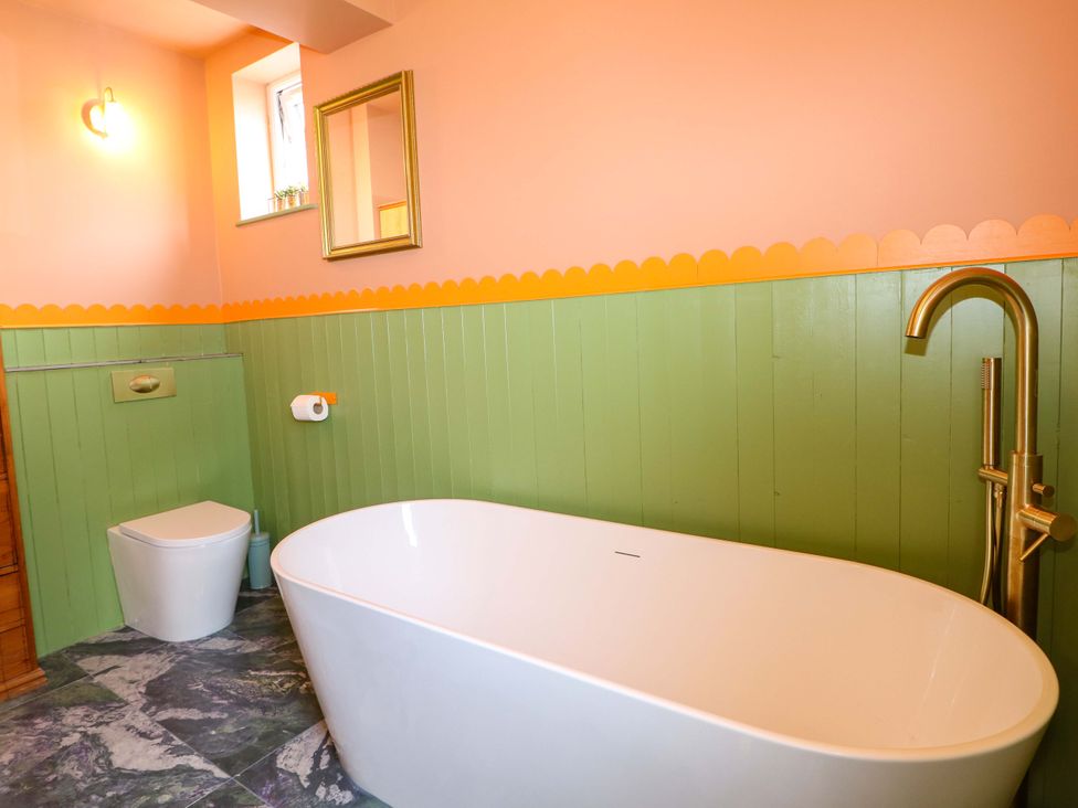 A bathroom with a bathtub, toilet and sink at Hasting Heights in Hastings