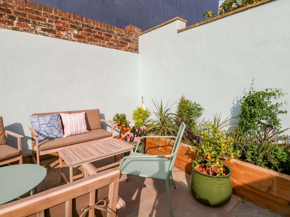 A garden seating area with plants and garden furniture at Hasting Heights in Hastings