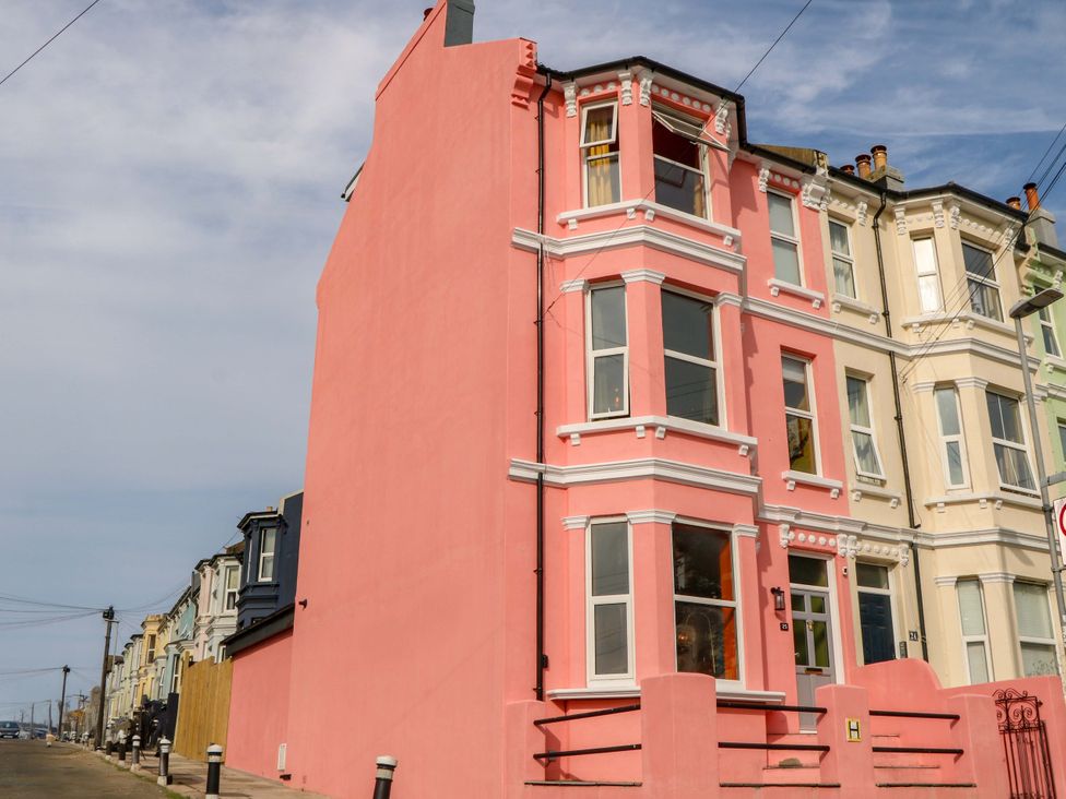 A pink building with multiple windows and a street at Hasting Heights, Hastings