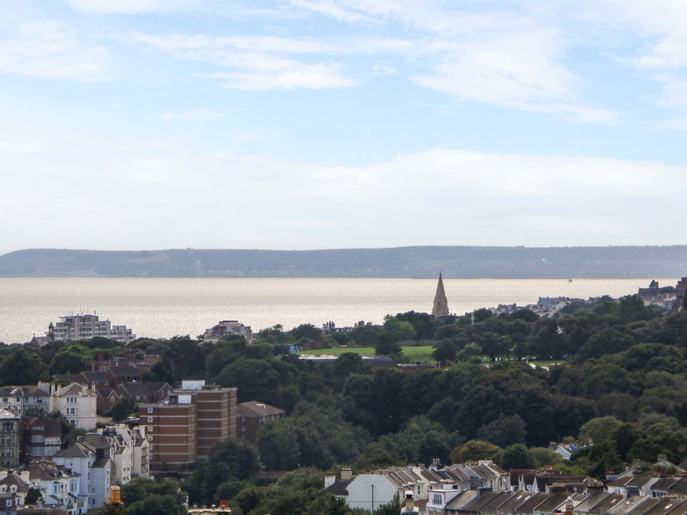 A view of the sea and buildings with trees at Hasting Heights in Hastings