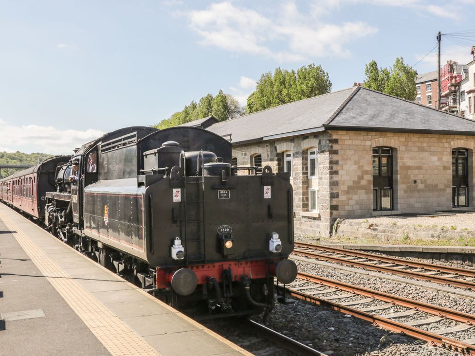 A steam locomotive and train carriage at a railway station
