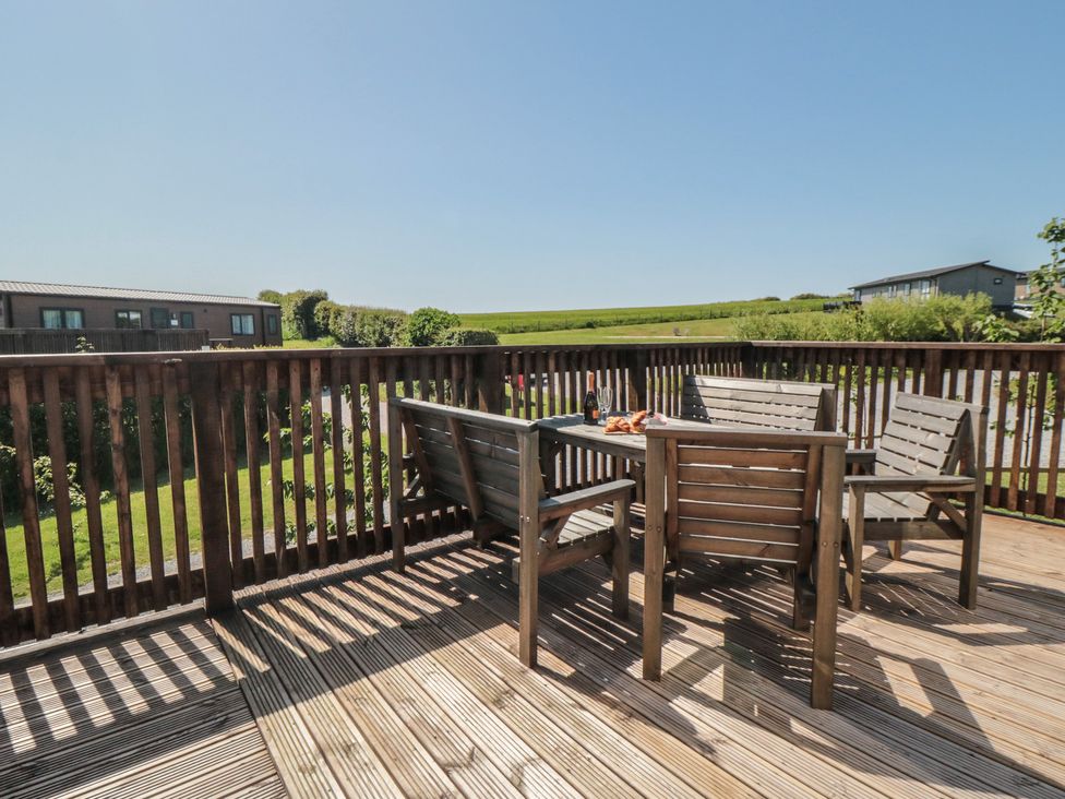 A deck area with wooden furniture at Maple Lodge in Whitby