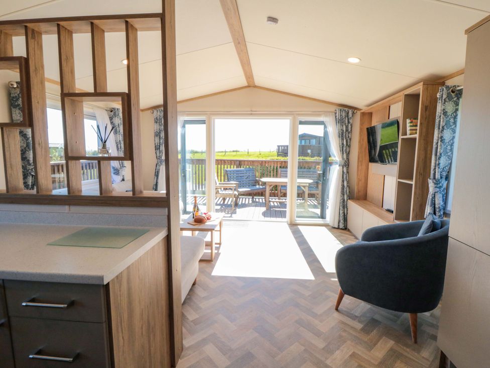 A living room with a sofa and television at Fir Lodge in Whitby