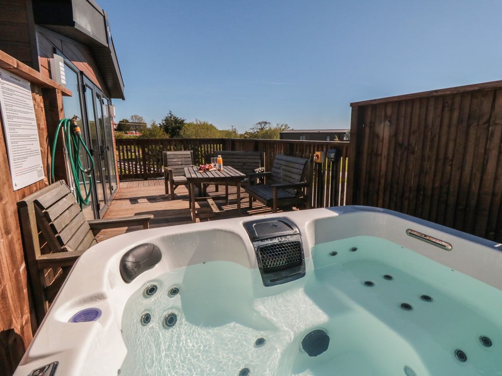A hot tub on a wooden deck at Fir Lodge in Whitby