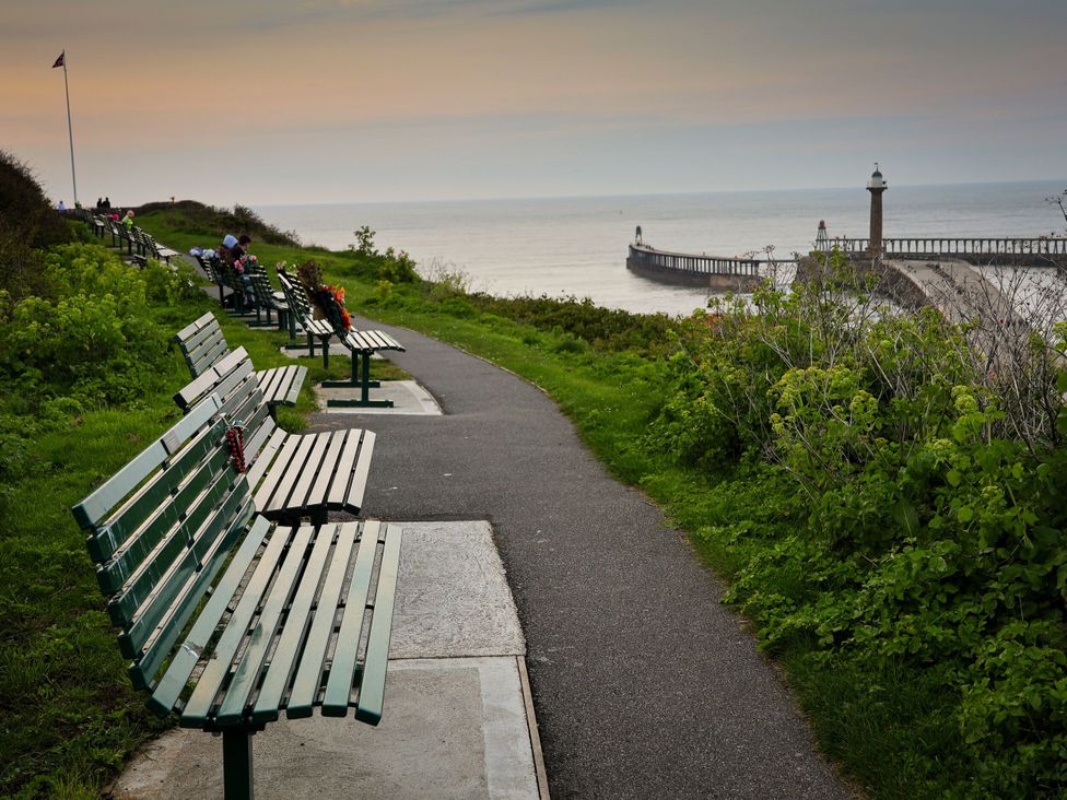 A pathway with benches overlooking the sea at Cherry Blossom Lodge in Whitby