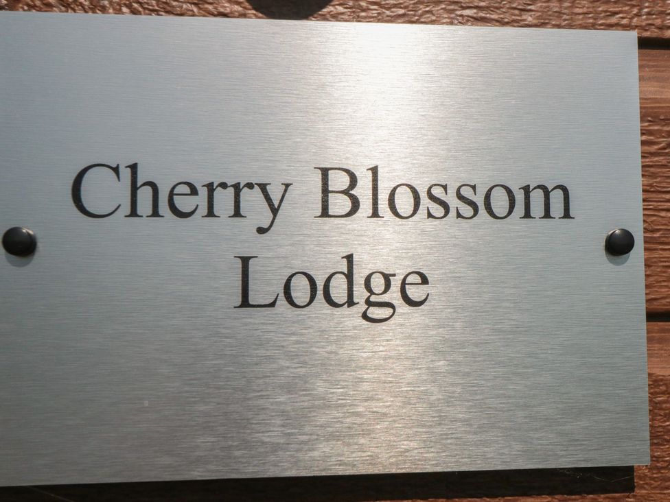 A sign displaying the name Cherry Blossom Lodge