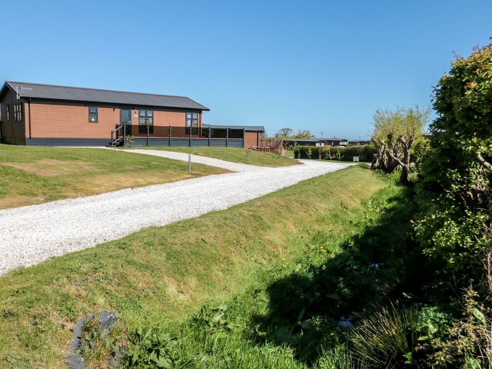 An outdoor view of a lodge with a gravel path at Cherry Blossom Lodge in Whitby