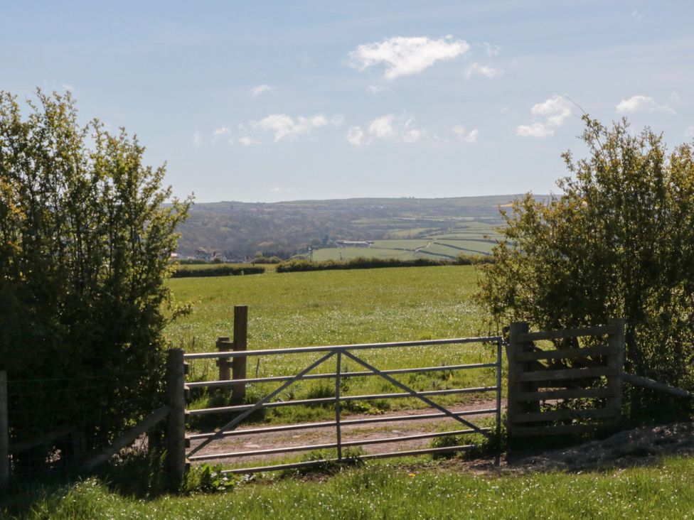 A gate leading to a field with hills in the background at Holly Lodge, Whitby