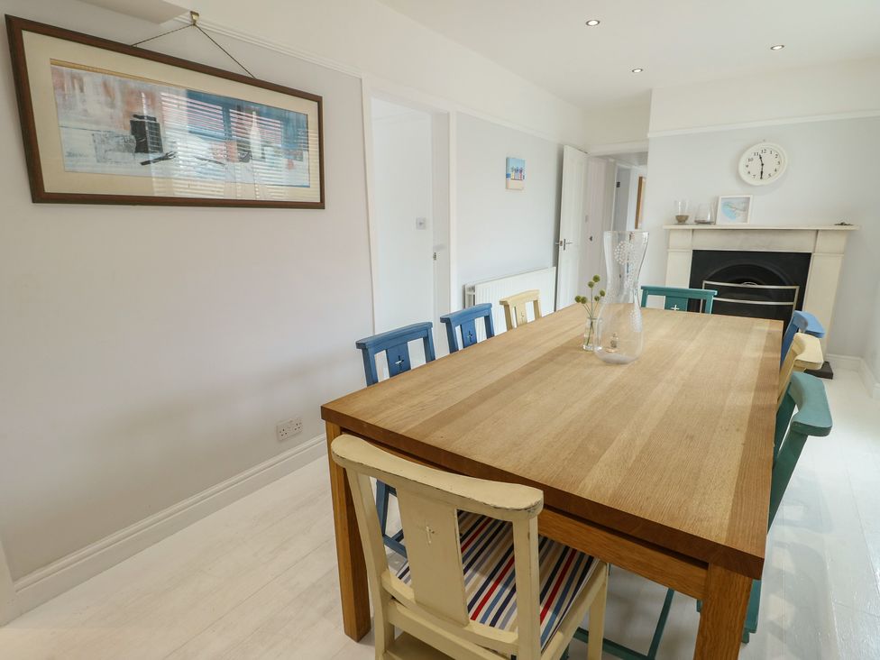 A dining room with a wooden table and colorful chairs at Gorse Hill
