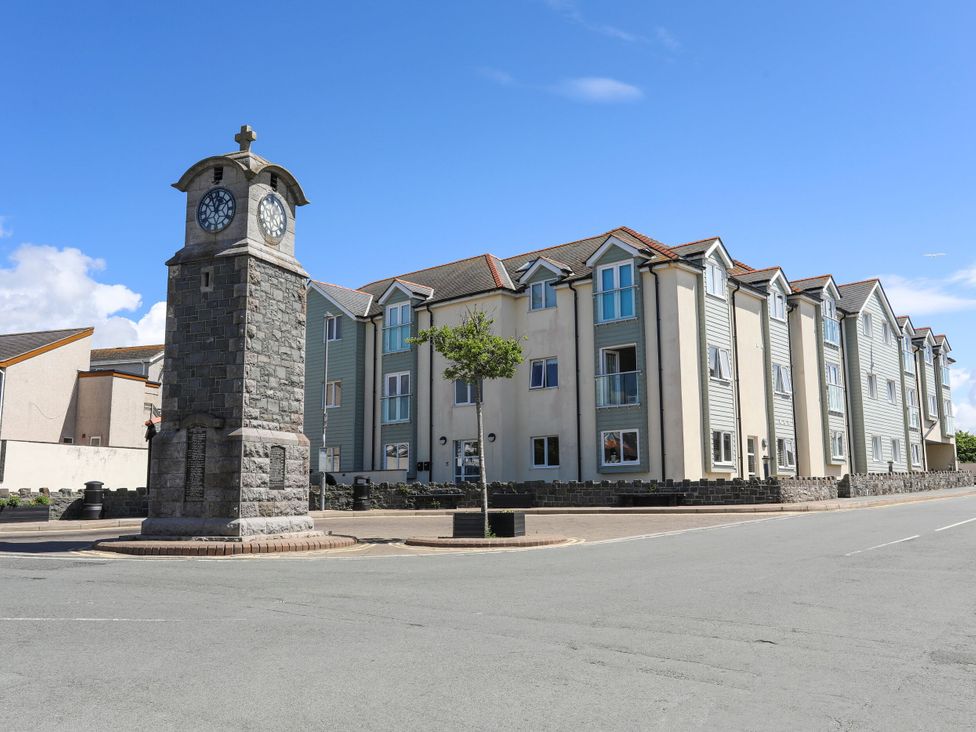 A clock tower next to a residential building at Gorse Hill in Rhosneigr