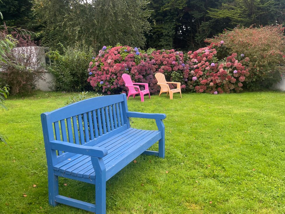 A garden with a blue bench and flowering bushes at Dromclough Farmhouse in Dromclough near Listowel, County Kerry