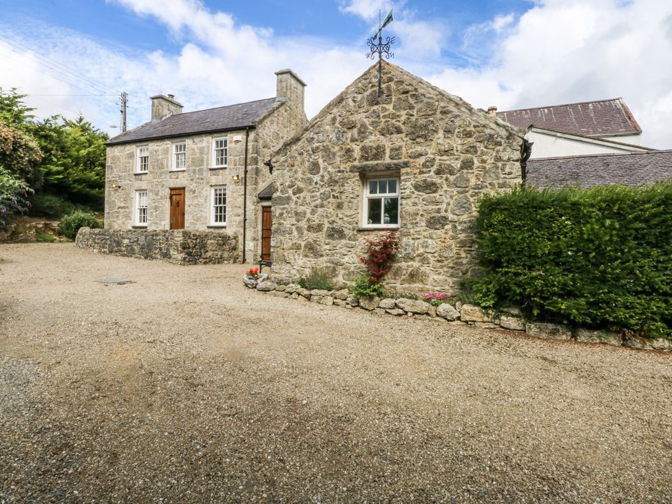 Two stone houses with a gravel pathway at Tyddyn Iolyn Benllech