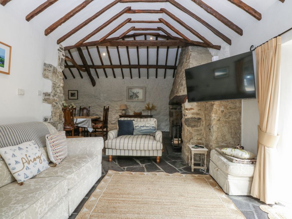 A living room with a sofa and television at Tyddyn Iolyn in Benllech