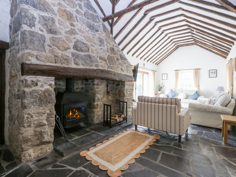A living room with a fireplace and sofa at Tyddyn Iolyn Benllech