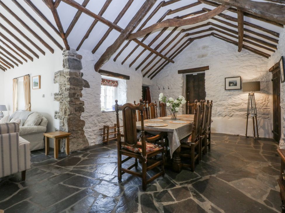 A dining room with a table and chairs at Tyddyn Iolyn in Benllech