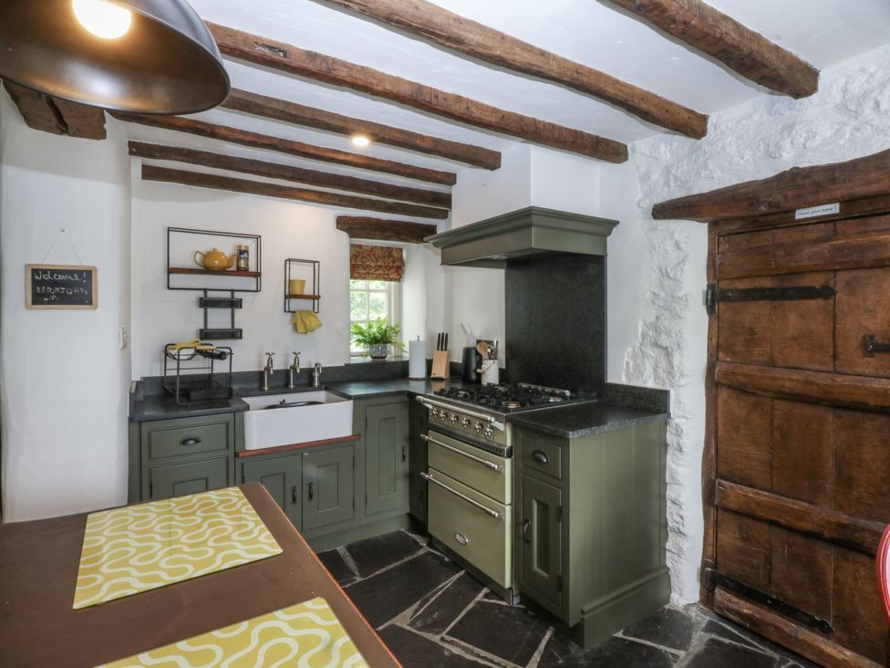 A kitchen with a stove and sink at Tyddyn Iolyn in Benllech