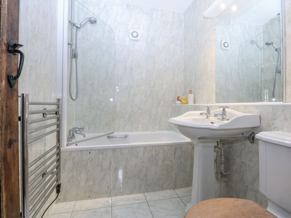 A bathroom with a shower, bathtub, sink, and toilet at Tyddyn Iolyn in Benllech