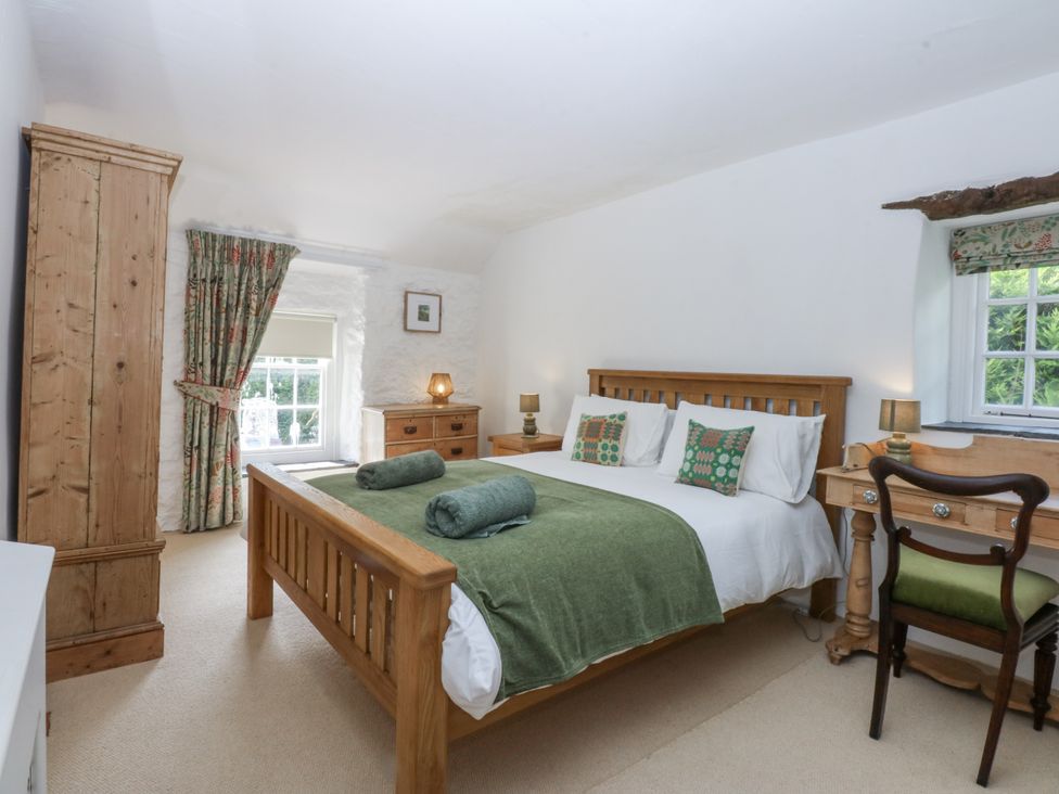 A bedroom with a bed and desk at Tyddyn Iolyn in Benllech