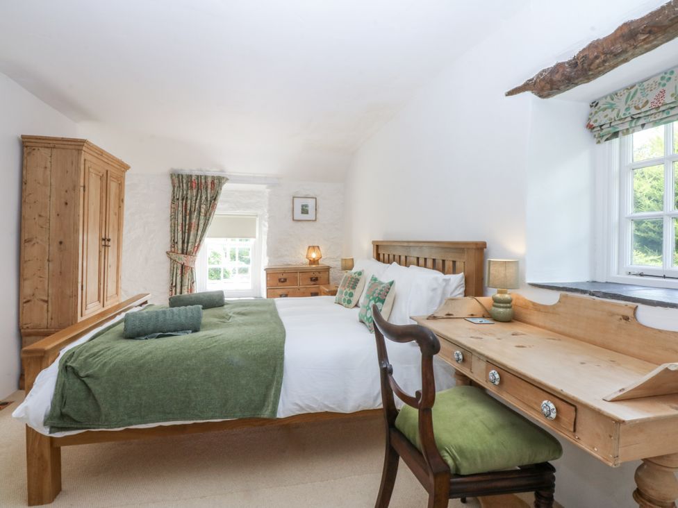 A bedroom with a double bed and wooden furniture at Tyddyn Iolyn in Benllech