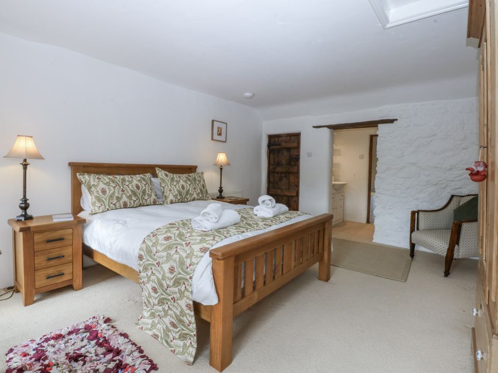 A bedroom with a bed and nightstand at Tyddyn Iolyn in Benllech
