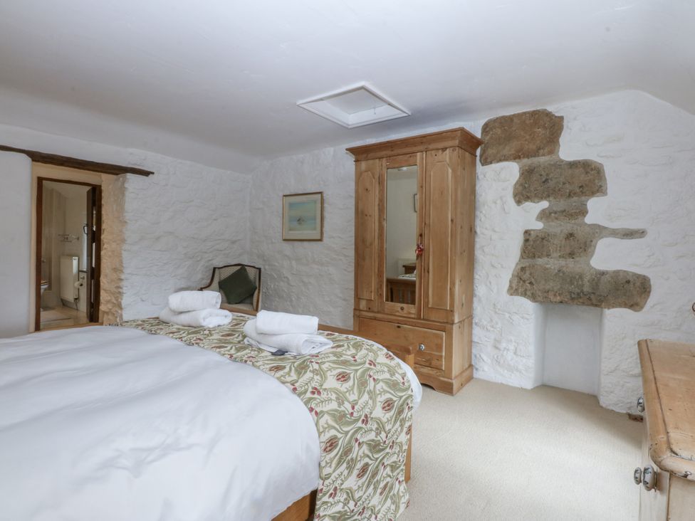 A bedroom with a bed and wardrobe at Tyddyn Iolyn in Benllech