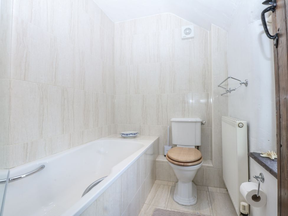 A bathroom with a bathtub and toilet at Tyddyn Iolyn in Benllech