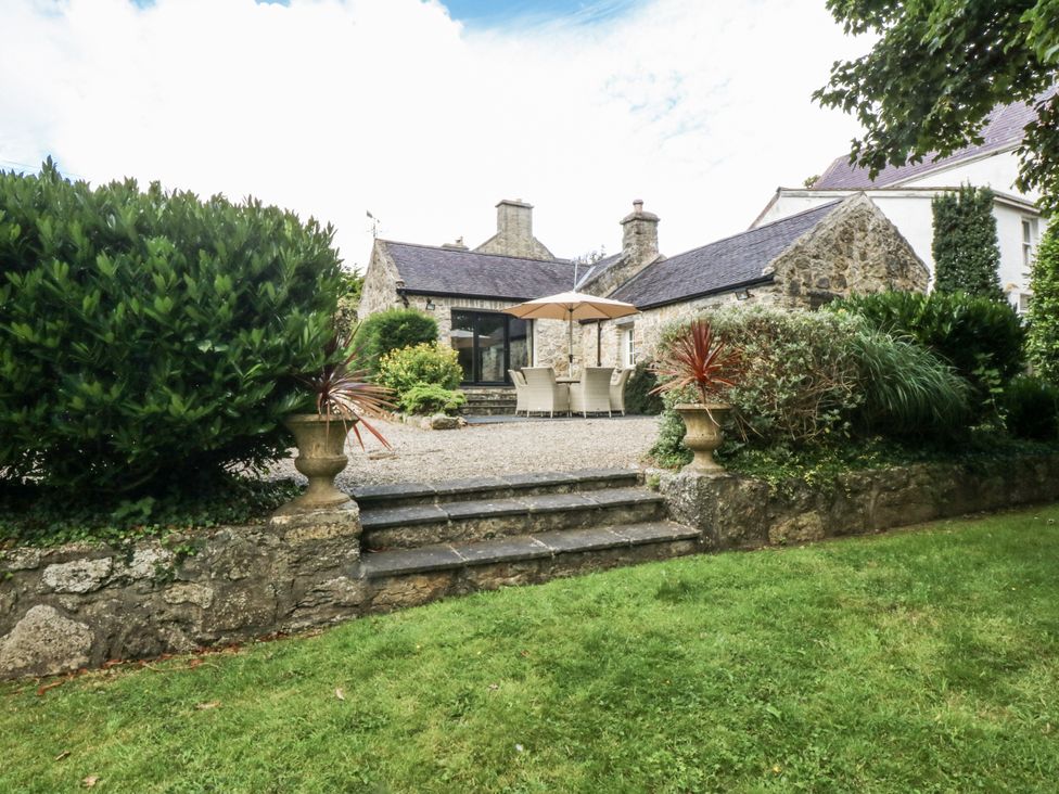 A garden with steps and outdoor furniture at Tyddyn Iolyn in Benllech