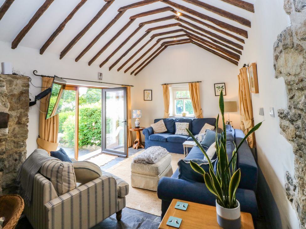 A living room with a sofa and a television at Tyddyn Iolyn in Benllech