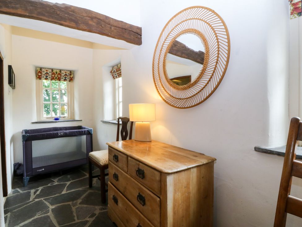 An entryway with a dresser and playpen at Tyddyn Iolyn in Benllech